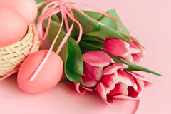 Ostereier im Korb auf dem rosa Pastellhintergrund verziert mit Tulpen glückliches neues Jahr 2007 stockbild Ostereier im Korb auf dem rosa Pastellhintergrund verziert mit Tulpen glückliches neues Jahr 2007 stockbild