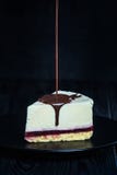 Ostkaka på den mörka plattan som är dold vid choklad royaltyfria foton Ostkaka på den mörka plattan som är dold vid choklad royaltyfria foton