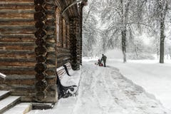 Oude houten kerk Het landschap van de winter Een arbeider verwijdert Sn stock fotografie Oude houten kerk Het landschap van de winter Een arbeider verwijdert Sn stock fotografie