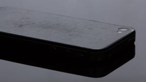 Oude smartphone die de film heeft gekrast Op zwarte achtergrond royalty-vrije stock afbeelding Oude smartphone die de film heeft gekrast Op zwarte achtergrond royalty-vrije stock afbeelding