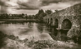Oude steenbrug met bogen, humeurige hemel, landschap in sepia stock foto's Oude steenbrug met bogen, humeurige hemel, landschap in sepia stock foto's