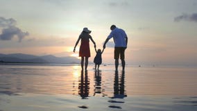 Ouders die baby rond op strand slingeren bij zonsondergang stock video Ouders die baby rond op strand slingeren bij zonsondergang stock video