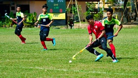 Outdoor Hockey. Hockey player in action during the Thailand National Games royalty free stock photo Outdoor Hockey. Hockey player in action during the Thailand National Games royalty free stock photo