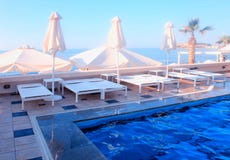 Outdoor sun beds near swimming pool on summer resort Royalty Free Stock Images Outdoor sun beds near swimming pool on summer resort Royalty Free Stock Images