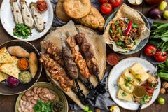 Outdoors Food Concept. Appetizing barbecued steak, sausages and grilled vegetables on a wooden picnic table. royalty free stock images Outdoors Food Concept. Appetizing barbecued steak, sausages and grilled vegetables on a wooden picnic table. royalty free stock images