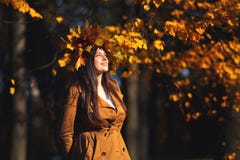 Outdoors lifestyle close up portrait of charming young woman wearing a wreath of autumn leaves. walking on the autumn stock image Outdoors lifestyle close up portrait of charming young woman wearing a wreath of autumn leaves. walking on the autumn stock image