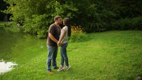 Outdoors portrait of the lovely couple kissing at the city park. Woman and man in love outside.