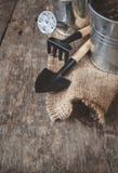 Outil de jardin, pelle, râteau, boîte d'arrosage, seau, sac sur un en bois Photos libres de droits Outil de jardin, pelle, râteau, boîte d'arrosage, seau, sac sur un en bois Photos libres de droits