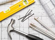 Outils de construction avec le marteau, les clous, la règle de pliage et le niveau sur la configuration plate de plan architectur image stock Outils de construction avec le marteau, les clous, la règle de pliage et le niveau sur la configuration plate de plan architectur image stock
