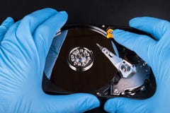 Ouvrez le lecteur de disque dur dans des mains dans les gants bleus images stock Ouvrez le lecteur de disque dur dans des mains dans les gants bleus images stock