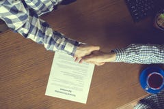 Overhead top view of two workers in casual in the office signing the contract agreement on table stock photo Overhead top view of two workers in casual in the office signing the contract agreement on table stock photo