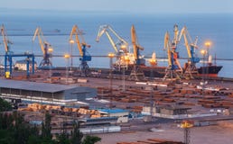 Overzeese commerciële haven bij nacht in Mariupol, de Oekraïne Industriële Mening Het schip van de ladingsvracht met werkende kra Royalty-vrije Stock Foto Overzeese commerciële haven bij nacht in Mariupol, de Oekraïne Industriële Mening Het schip van de ladingsvracht met werkende kra Royalty-vrije Stock Foto