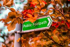 Общественная тропа подписывает в Великобритании против дерева в Autum стоковые фотографии rf Общественная тропа подписывает в Великобритании против дерева в Autum стоковые фотографии rf