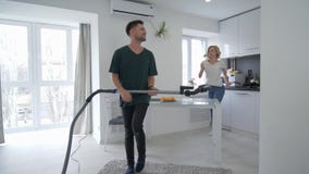 Paar in der Liebe hat Spaß in der Küche, glücklicher Mann tanzt mit Staubsauger mit Mädchen, dem mit einem Schöpflöffel wie singt stock video footage Paar in der Liebe hat Spaß in der Küche, glücklicher Mann tanzt mit Staubsauger mit Mädchen, dem mit einem Schöpflöffel wie singt stock video footage