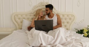 Paar het liggen bed die laptop computer, de man van het mengelingsras de ochtendslaapkamer met behulp van van de vrouwenglimlach stock video Paar het liggen bed die laptop computer, de man van het mengelingsras de ochtendslaapkamer met behulp van van de vrouwenglimlach stock video