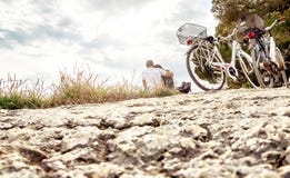 Paar op een fietsreis Minnaars die op strand zitten royalty-vrije stock foto's Paar op een fietsreis Minnaars die op strand zitten royalty-vrije stock foto's