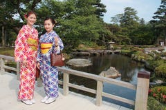 Paar van meisjes die kleurrijke traditionele Japanse kimono in Kenrokuen, de beroemde Japanse landschapstuin in Kanazawa Japan dr Stock Afbeeldingen Paar van meisjes die kleurrijke traditionele Japanse kimono in Kenrokuen, de beroemde Japanse landschapstuin in Kanazawa Japan dr Stock Afbeeldingen