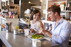 Paare, die Mittagessen-Datum im Delikatessen-Restaurant genießen lizenzfreie stockbilder Paare, die Mittagessen-Datum im Delikatessen-Restaurant genießen lizenzfreie stockbilder