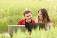 Paare oder Freunde, die Laptops auf einem Gebiet aufpassen lizenzfreie stockfotos Paare oder Freunde, die Laptops auf einem Gebiet aufpassen lizenzfreie stockfotos