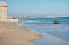 Paarzitting dichtbij steenachtige toren op het strand van La Mata, Spanje royalty-vrije stock foto Paarzitting dichtbij steenachtige toren op het strand van La Mata, Spanje royalty-vrije stock foto