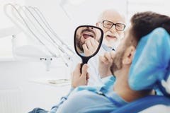 Paciente masculino joven con respecto a sus dientes imágenes de archivo libres de regalías Paciente masculino joven con respecto a sus dientes imágenes de archivo libres de regalías