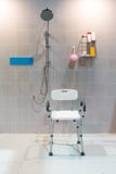 Padded shower chair with arms and back in bathroom with bright t royalty free stock photos Padded shower chair with arms and back in bathroom with bright t royalty free stock photos