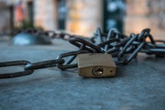 Paddlock with chain, on surface, outdoors, closeup stock photo Paddlock with chain, on surface, outdoors, closeup stock photo