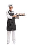 Padeiro que guarda uma bandeja com os nacos de pão fotografia de stock Padeiro que guarda uma bandeja com os nacos de pão fotografia de stock