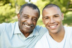 Padre afroamericano And Adult Son que se relaja en parque foto de archivo libre de regalías Padre afroamericano And Adult Son que se relaja en parque foto de archivo libre de regalías