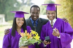 Padre con dos graduados afuera Padre con dos graduados afuera
