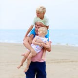 Padre con i bambini divertendosi sulla spiaggia immagini stock libere da diritti Padre con i bambini divertendosi sulla spiaggia immagini stock libere da diritti