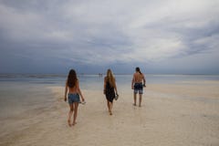 Padre de la familia con las hijas que caminan en la playa hermosa de Galu - de Kinondo en Kenia, costa, durante la bajamar Imagenes de archivo Padre de la familia con las hijas que caminan en la playa hermosa de Galu - de Kinondo en Kenia, costa, durante la bajamar Imagenes de archivo