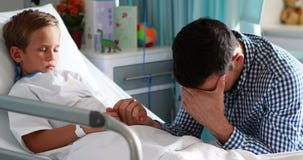 Padre depresso che tiene la sua mano del figlio stock footage Padre depresso che tiene la sua mano del figlio stock footage