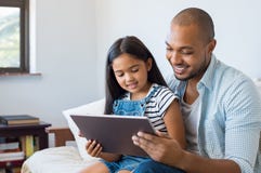 Padre e hija que usa la tableta foto de archivo Padre e hija que usa la tableta foto de archivo
