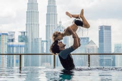 Padre e hijo en piscina al aire libre con la opinión de la ciudad en s azul fotografía de archivo libre de regalías Padre e hijo en piscina al aire libre con la opinión de la ciudad en s azul fotografía de archivo libre de regalías
