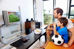Padre e hijo que ven la TV junto fotos de archivo libres de regalías Padre e hijo que ven la TV junto fotos de archivo libres de regalías