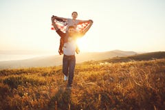 Padre feliz y ni?o de la familia con la bandera de Estados Unidos que disfrutan de puesta del sol en la naturaleza fotografía de archivo libre de regalías Padre feliz y ni?o de la familia con la bandera de Estados Unidos que disfrutan de puesta del sol en la naturaleza fotografía de archivo libre de regalías