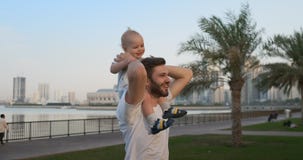 Padre que camina con un niño que se sienta en el cuello metrajes Padre que camina con un niño que se sienta en el cuello metrajes