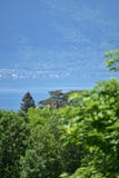Paesaggio del lago Lemano fra alcuni alberi con bokeh in prima terra fotografia stock libera da diritti Paesaggio del lago Lemano fra alcuni alberi con bokeh in prima terra fotografia stock libera da diritti