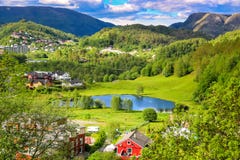 Paesaggio della primavera con la panoramica di una valle tranquilla con i prati verdi, uno stagno e le Camere variopinte dell'azi fotografie stock Paesaggio della primavera con la panoramica di una valle tranquilla con i prati verdi, uno stagno e le Camere variopinte dell'azi fotografie stock