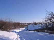 Paesaggio di inverno del villaggio russo nel percorso neve-calpestato attraverso le derive un chiaro giorno soleggiato in natura fotografia stock libera da diritti Paesaggio di inverno del villaggio russo nel percorso neve-calpestato attraverso le derive un chiaro giorno soleggiato in natura fotografia stock libera da diritti