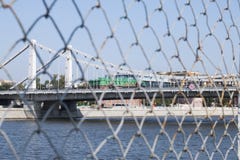 Paesaggio di un ponte sospeso sopra il fiume di Moskva Una vista da dietro la griglia fotografia stock libera da diritti Paesaggio di un ponte sospeso sopra il fiume di Moskva Una vista da dietro la griglia fotografia stock libera da diritti