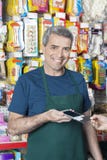 Pagamento de sorriso de Accepting Credit Card do vendedor do cliente imagens de stock royalty free Pagamento de sorriso de Accepting Credit Card do vendedor do cliente imagens de stock royalty free