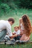 Pai bonito novo, mãe e filho pequeno da criança contra árvores verdes imagem de stock royalty free Pai bonito novo, mãe e filho pequeno da criança contra árvores verdes imagem de stock royalty free