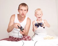 Pai e filho que jogam jogos fotografia de stock royalty free Pai e filho que jogam jogos fotografia de stock royalty free