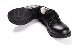 Paia della scarpa di cuoio nera nuovissima per i bambini su bianco immagine stock Paia della scarpa di cuoio nera nuovissima per i bambini su bianco immagine stock