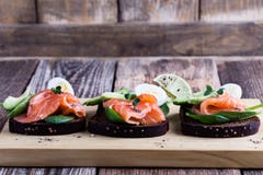 Pain de seigle grillé avec les légumes verts saumonés et frais fumés photo libre de droits Pain de seigle grillé avec les légumes verts saumonés et frais fumés photo libre de droits