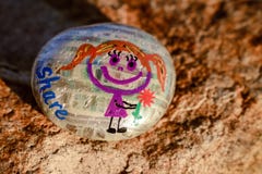 Painted Rock With Girl Holding Flower And Word Share Stock Photography