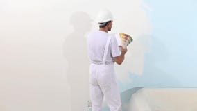 Painter man at work choice color with swatches samples, wall painting concept, white copy space