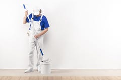 Painter man at work takes color with paint roller from the bucke royalty free stock photo Painter man at work takes color with paint roller from the bucke royalty free stock photo
